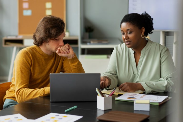 Collègues à coup moyen assis au bureau