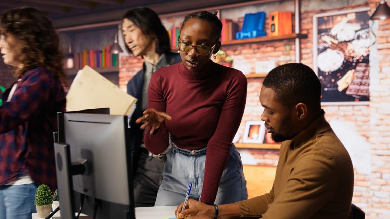 Des ingénieurs de start-up travaillant en équipe écrivant un message sur des no